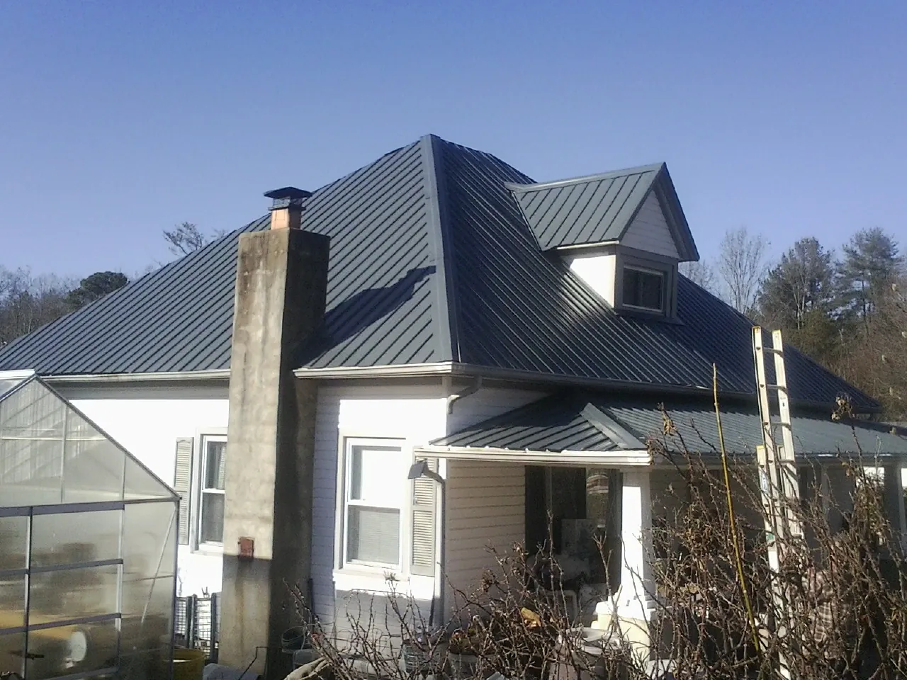 Dark blue standing seam metal roof on a white farmhouse with dormer — Slate & Tile Roof Repair by Roofing Brothers in Leck Kill