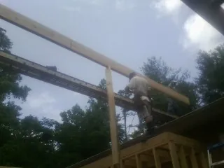 Carpenter setting a ridge beam over a new addition frame — Ice Dam Removal by Roofing Brothers in Leck Kill