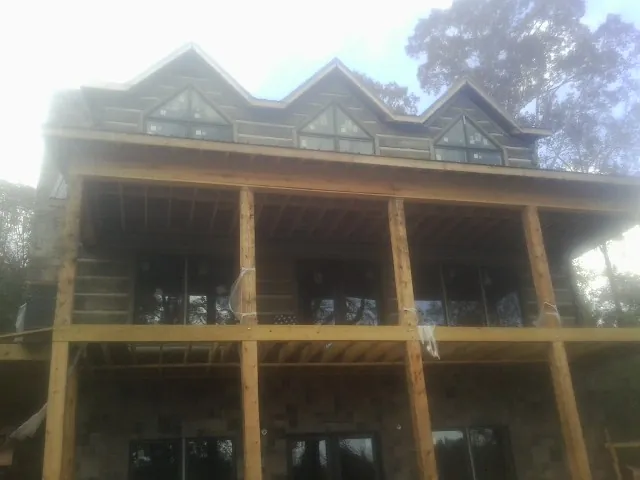 Dormers and porch framing on a large log home under construction — Roof Coating work by our crew in Leck Kill